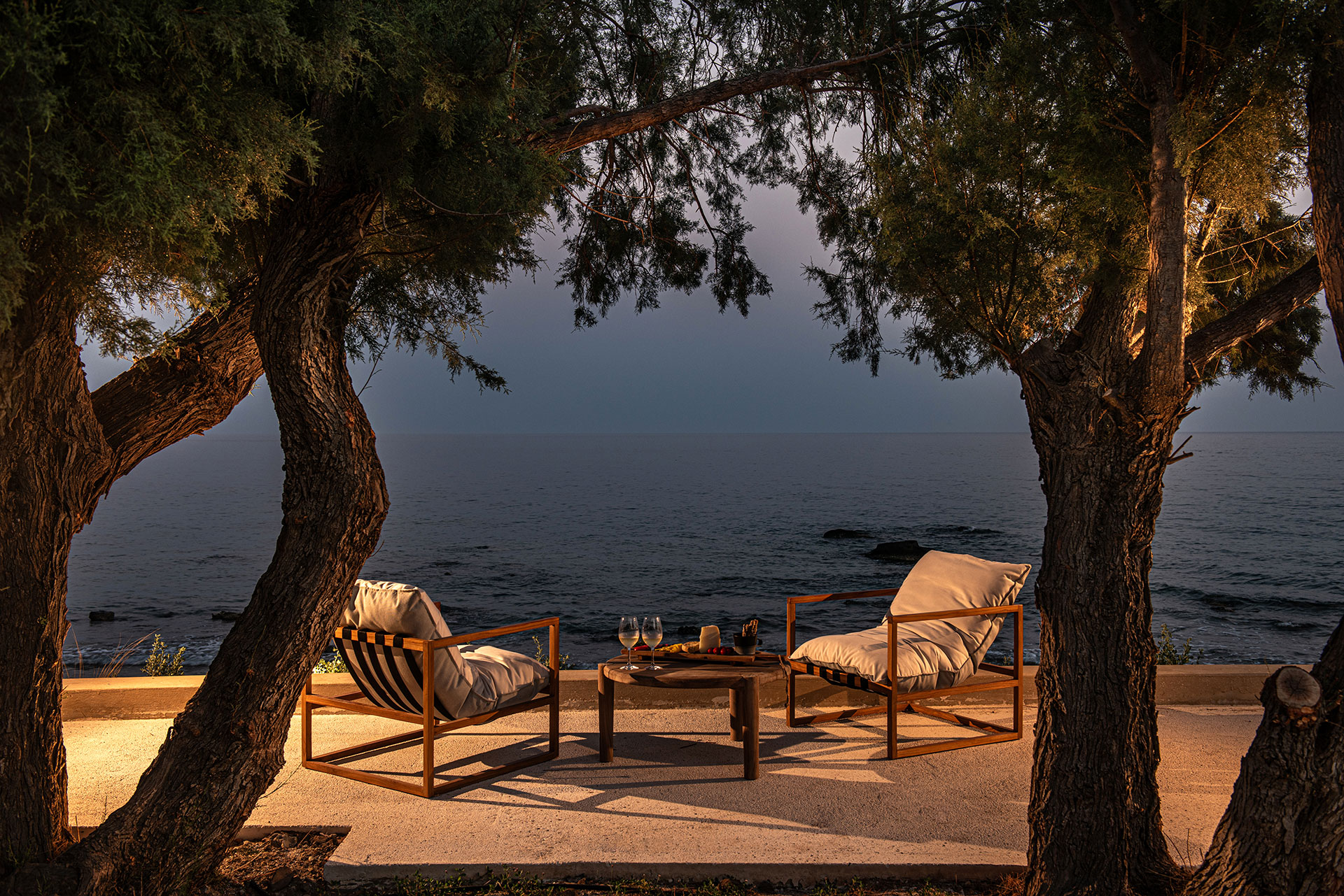 The Echo Of The Sea Beachfront Villa chairs and round table with the sea in the background at dusk